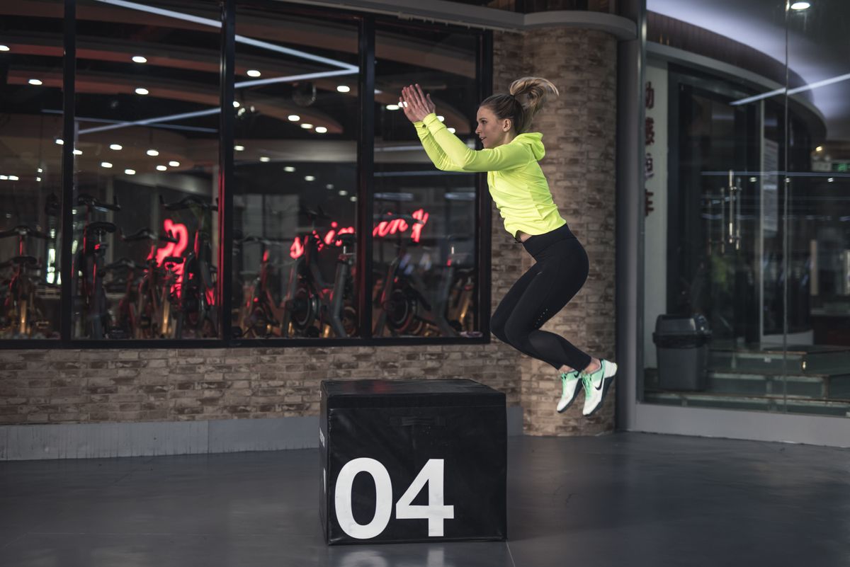 A crossfit athlete juping onto a box