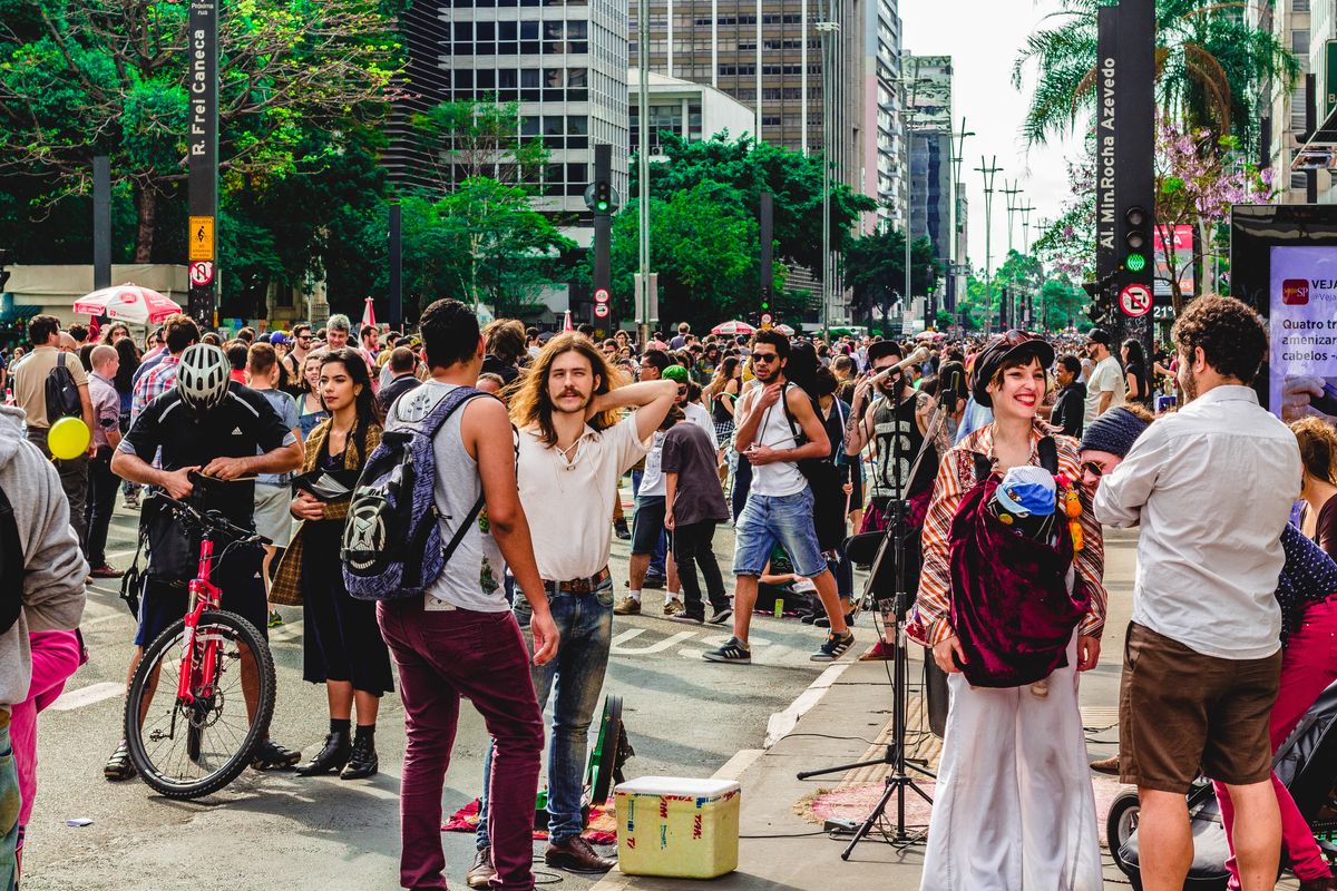 Dozens of people walk down a busy street in Sao Paolo, Brazil